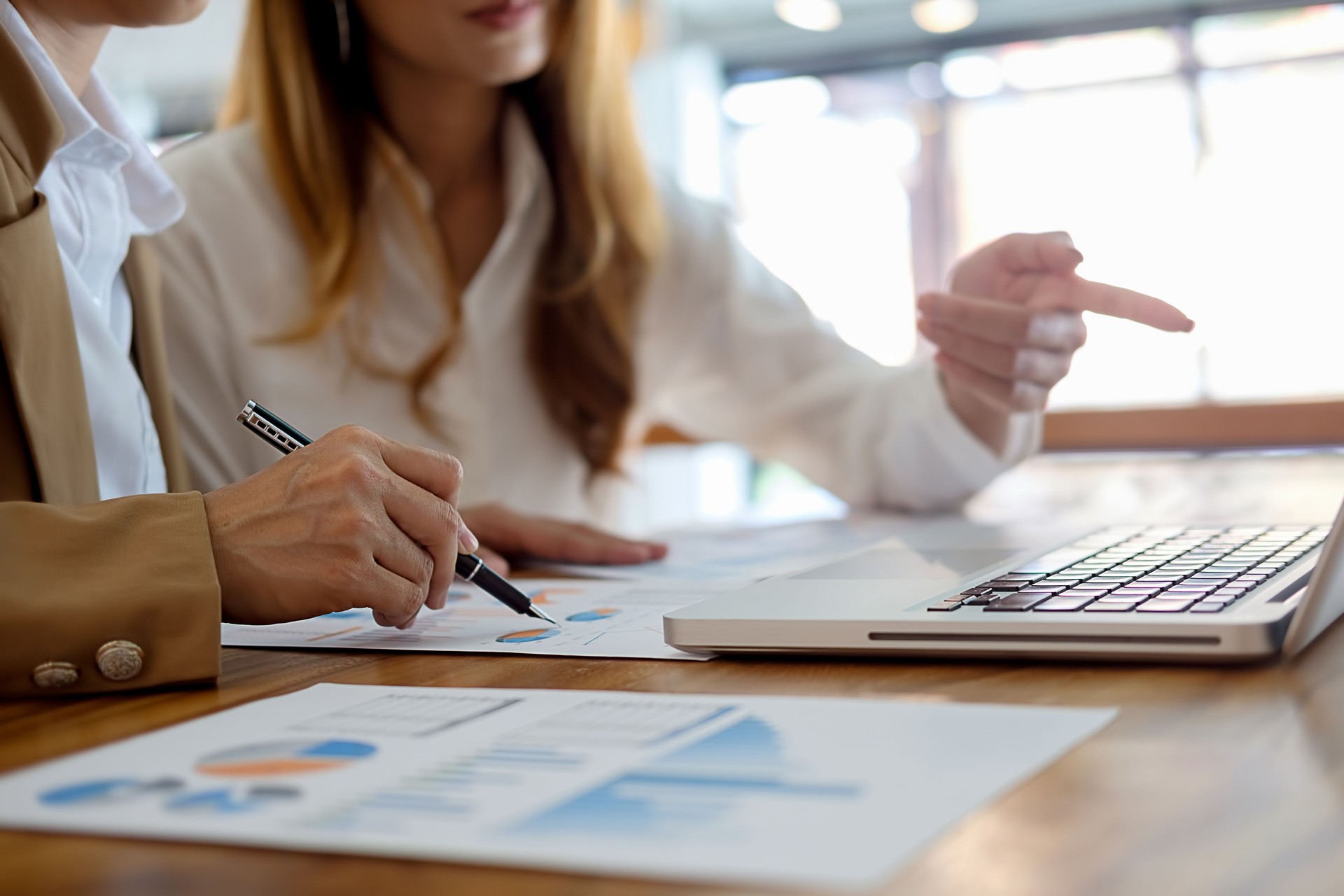 Concepto de negocio. Empresarios sobre las tablas y gráficos que muestran los resultados de su acertado trabajo en equipo.